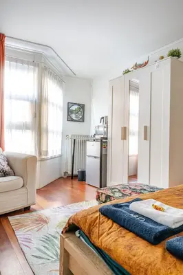 a living room with a bed and a kitchen at B Center charming room on the canal in Amsterdam