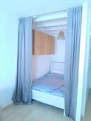 a bed with blue curtains in a room at Cozy Apartment in Alkmaar Centre in Alkmaar