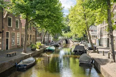 a river with boats in a city with buildings at Cozy Apartment in Alkmaar Centre in Alkmaar