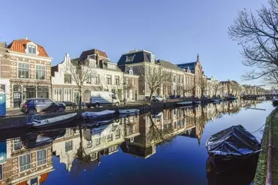 a river with houses and cars parked on the street at Cozy Apartment in Alkmaar Centre in Alkmaar