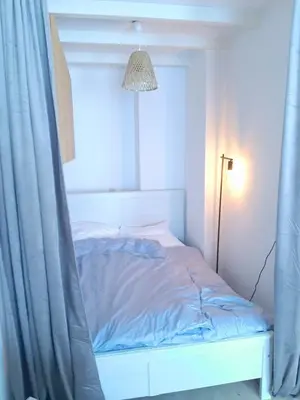 a bedroom with a bed with a curtain and a lamp at Cozy Apartment in Alkmaar Centre in Alkmaar