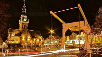 a large building with a clock tower at night at Cozy Apartment in Alkmaar Centre in Alkmaar
