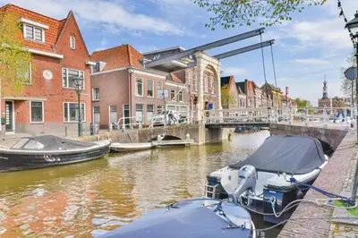 a couple of boats docked in a canal with buildings at De Laat Vintage in Alkmaar