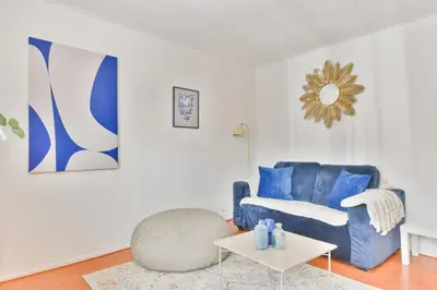 a living room with a blue chair and a table at De Laat Vintage in Alkmaar