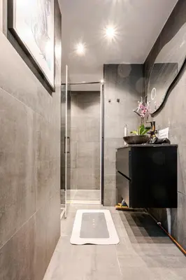 a bathroom with a shower and a white rug on the floor at SM Center located room on the canal in Amsterdam