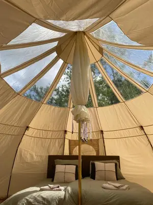 a bed in a tent with a large window at Luxe Glamping tent met sterrenhemel in Rijsenhout