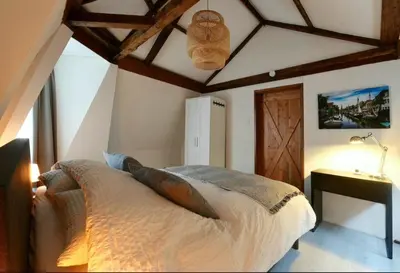 a bedroom with a bed and a ceiling with beams at Green City Apartement in Alkmaar