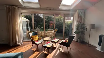 a living room with chairs and a couch and a table at Modern and luxury vacation house, private Jacuzzi in Zoetermeer