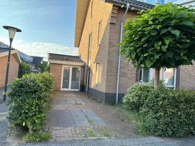 a brick house with a sidewalk in front of it at Modern and luxury vacation house, private Jacuzzi in Zoetermeer