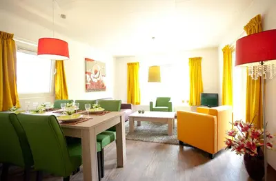 a dining room with a table and green chairs at EuroParcs Buitenhuizen in Velsen-Zuid