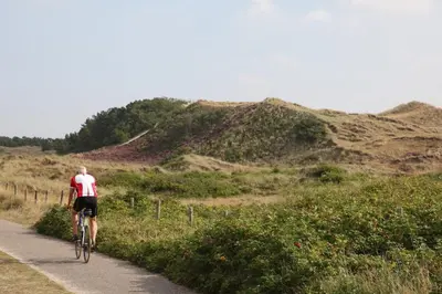 a man riding a bike down a dirt road at EuroParcs Molengroet in Noord-Scharwoude