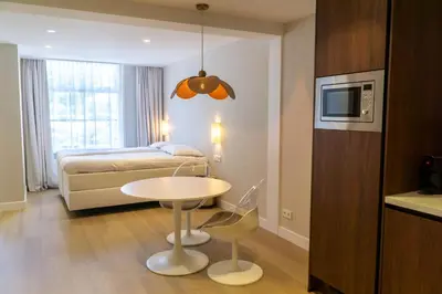 a hotel room with a bed and a table and a bed at Boerderie De Gouden Leeuw in Voorschoten