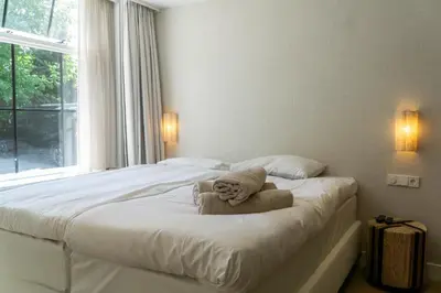 a teddy bear sitting on top of a bed at Boerderie De Gouden Leeuw in Voorschoten