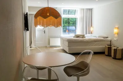 a room with a bed and a table and a bed at Boerderie De Gouden Leeuw in Voorschoten
