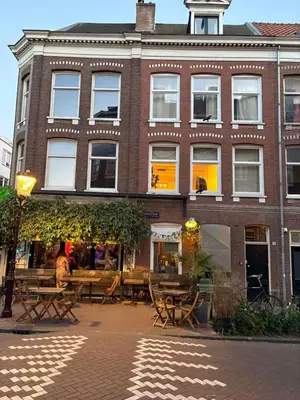 a building with tables and chairs in front of it at Bellamy Suites in Amsterdam