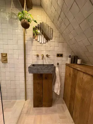 a bathroom with a sink and a tiled wall at Bellamy Suites in Amsterdam