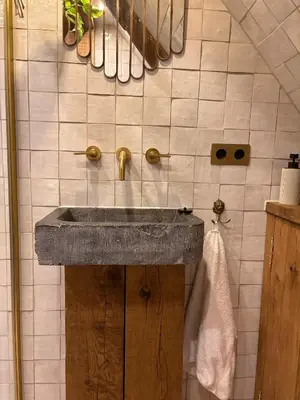 a bathroom with a stone sink in a room at Bellamy Suites in Amsterdam