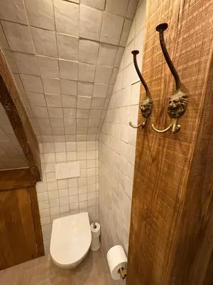 a bathroom with a toilet and two hangers on the wall at Bellamy Suites in Amsterdam