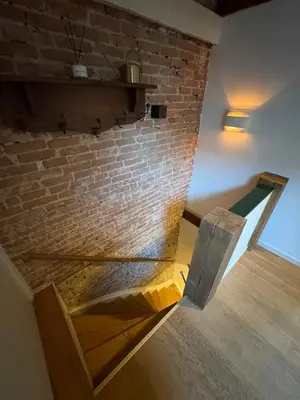 a brick wall with a wooden bench in a room at Bellamy Suites in Amsterdam