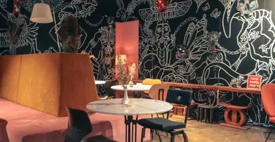 a room with tables and chairs and a black and white wall at De Groene Afslag Hotel in Bussum