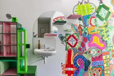 a bathroom with a sink and a colorful wall at De Groene Afslag Hotel in Bussum