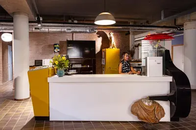 a woman standing behind a counter in a kitchen at De Groene Afslag Hotel in Bussum