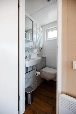 a bathroom with a toilet and a sink and a mirror at Floating Holiday Home - 15 mins to AMS in Vinkeveen