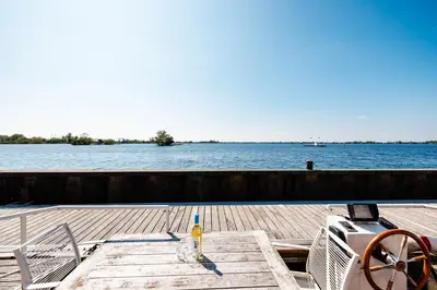 a table with a drink sitting on top of a boat at Floating Holiday Home - 15 mins to AMS in Vinkeveen