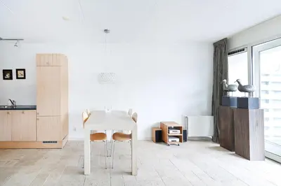 a white dining room with a white table and chairs at Boathouse Suburban Amsterdam in Uitgeest