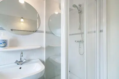a white bathroom with a shower and a sink at Boathouse Suburban Amsterdam in Uitgeest