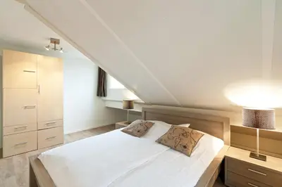 a bedroom with a white bed with two pillows at Boathouse Suburban Amsterdam in Uitgeest