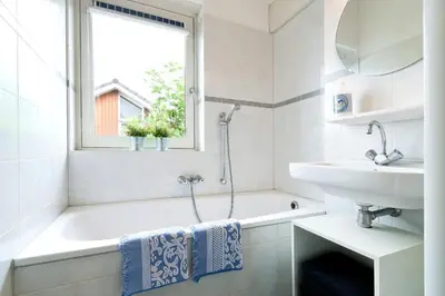 a white bathroom with a tub and a sink at Boathouse Suburban Amsterdam in Uitgeest