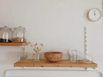 a wooden shelf with glass jars and a clock at Unique Tiny House close to Ams Airport with Hottub in Rijsenhout