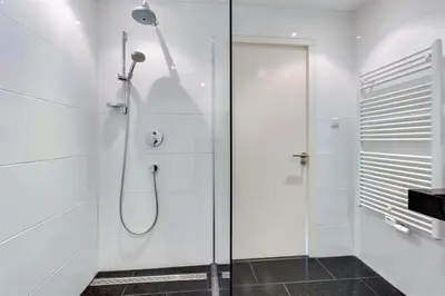 a shower with a glass door in a bathroom at Lil Amsterdam Topfloor a room ensuite with balcony in Uithoorn
