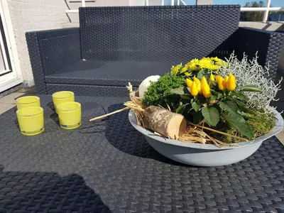 a bowl of flowers on a table with two cups at Lil Amsterdam Topfloor a room ensuite with balcony in Uithoorn