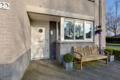 a wooden bench sitting outside of a building with a door at Lil Amsterdam Topfloor a room ensuite with balcony in Uithoorn