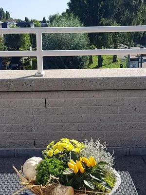 a basket of flowers on a table next to a wall at Lil Amsterdam Topfloor a room ensuite with balcony in Uithoorn
