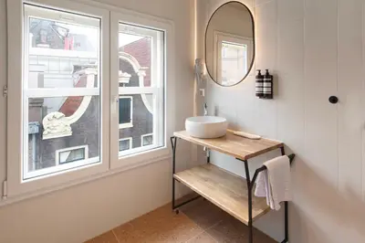 a bathroom with a sink and a window at Hotel Zeedijk City Centre in Amsterdam