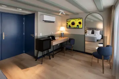 a room with a vanity with a mirror and a bedroom at Hotel Zeedijk City Centre in Amsterdam