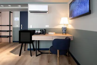 a desk in a room with two chairs and a lamp at Hotel Zeedijk City Centre in Amsterdam