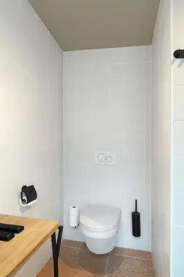 a white bathroom with a toilet in the corner at Hotel Zeedijk City Centre in Amsterdam