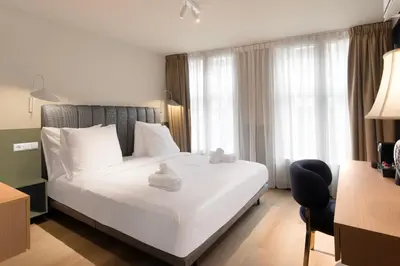 a bedroom with a large white bed with white pillows at Hotel Zeedijk City Centre in Amsterdam