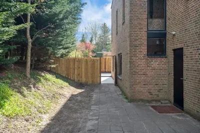 a brick building with a sidewalk next to a fence at Blissea in Zandvoort