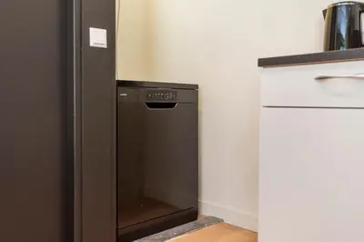 a black refrigerator in a kitchen next to a counter at Blissea in Zandvoort