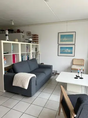 a living room with a couch and a table at Gemütliches Ferienhaus am Meer in Ons Belang