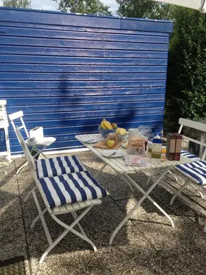 a table and chairs with a plate of food on it at Gemütliches Ferienhaus am Meer in Ons Belang