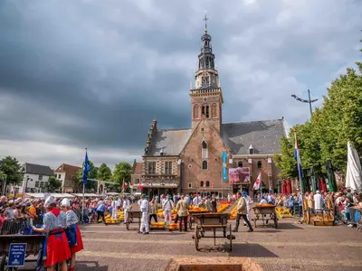 a crowd of people standing in front of a building with a clock tower at Vorstelijk verblijf Alkmaar in Alkmaar