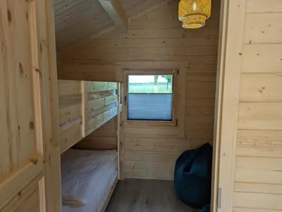 a room with two bunk beds in a log cabin at The Bee - Trekkershuts & Apartment in Opperdoes