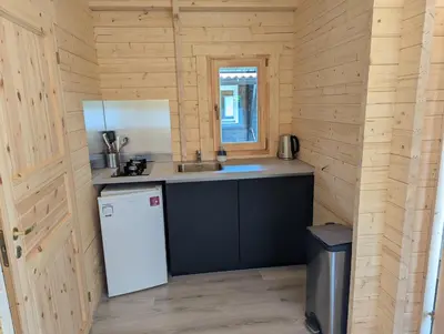 a kitchen with a white refrigerator and a sink at The Bee - Trekkershuts & Apartment in Opperdoes