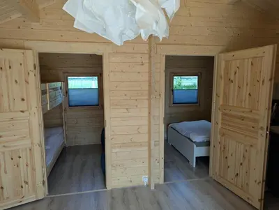 a log cabin with two beds and two windows at The Bee - Trekkershuts & Apartment in Opperdoes